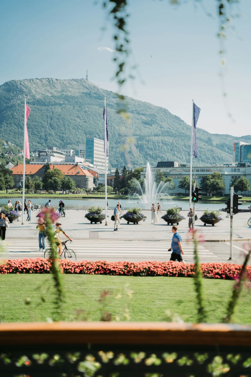 View of Lille Lungegårdsvannet fountain and surrounding park in central Bergen, Norway, with Mount Ulriken in the background on a sunny day View of Lille Lungegårdsvannet fountain and surrounding park in central Bergen, Norway, with Mount Ulriken in the background on a sunny day