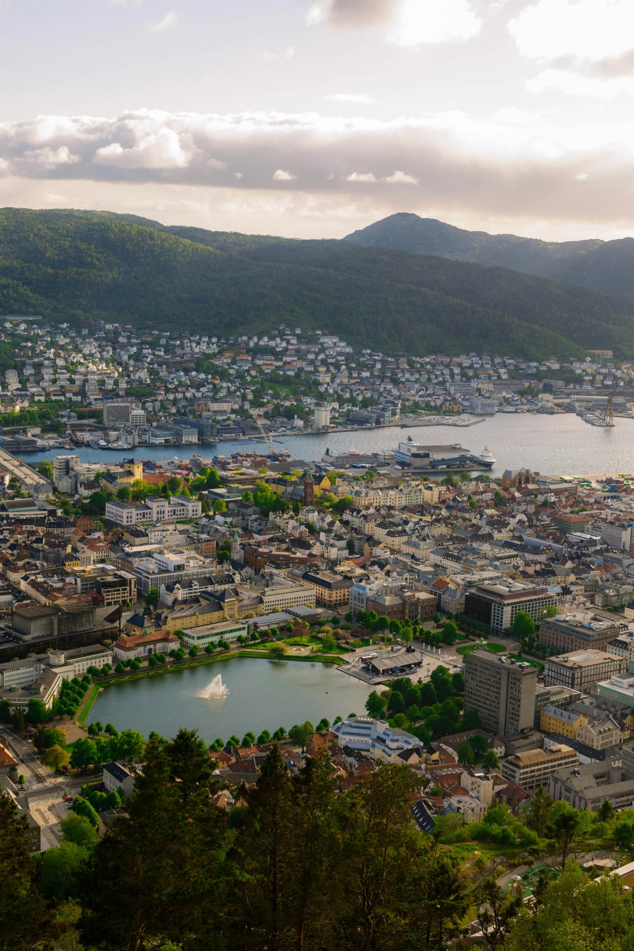 Aerial view of Bergen city, Norway, with surrounding mountains, harbour, and Lille Lungegårdsvannet lake in the foreground Aerial view of Bergen city, Norway, with surrounding mountains, harbour, and Lille Lungegårdsvannet lake in the foreground